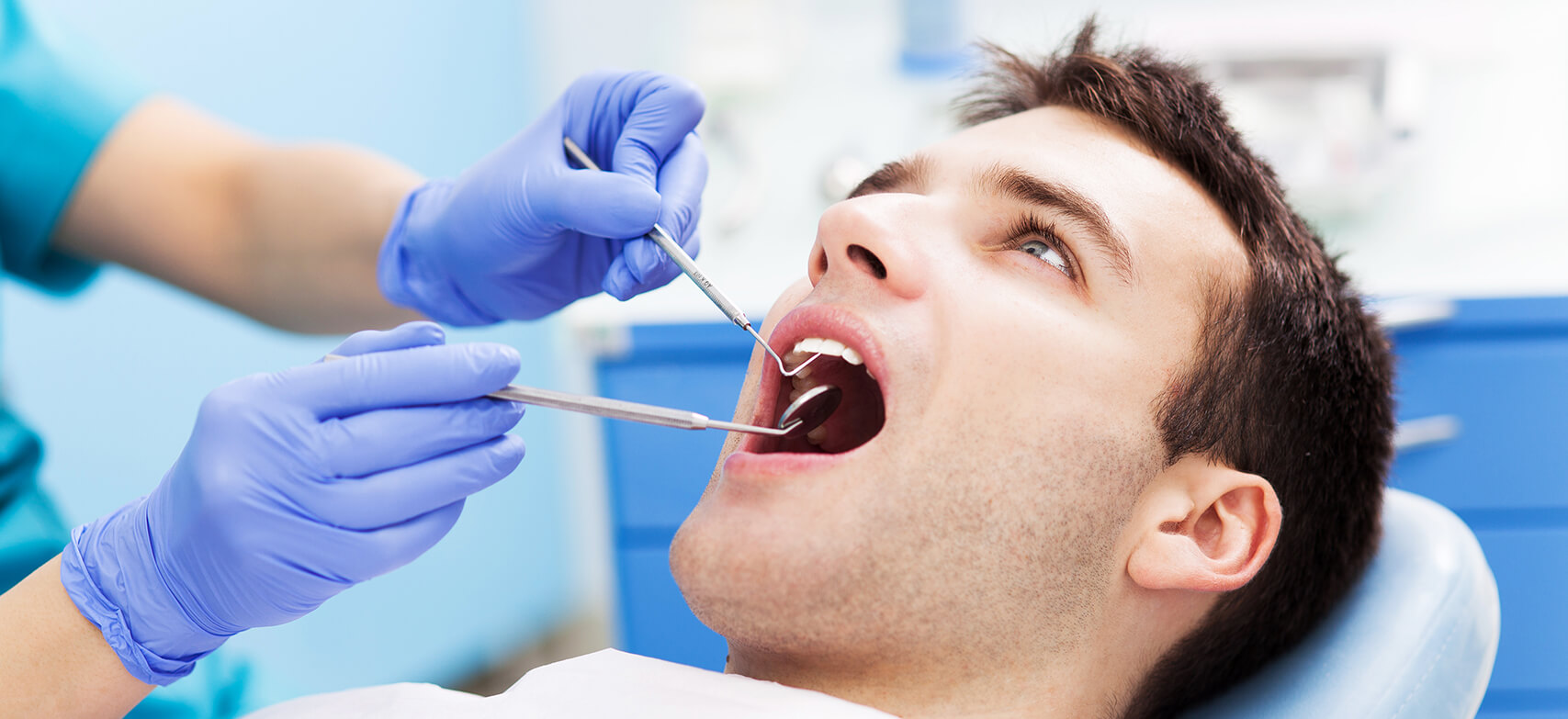 man having his teeth examined by a dentist