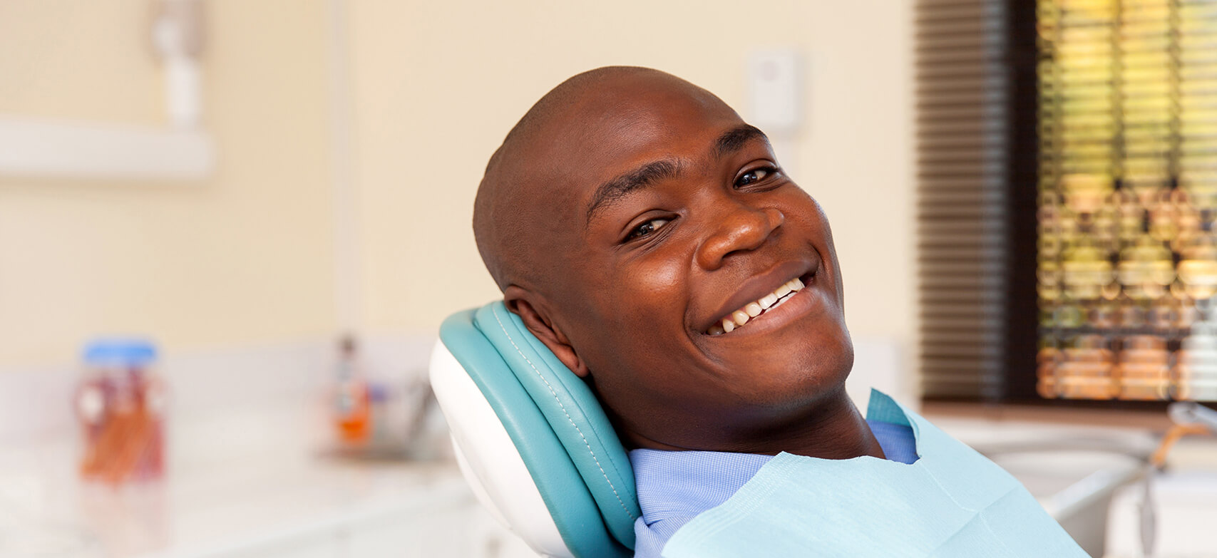 smiling man sitting in a dental chair