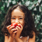 child eating a tooth-friendly snack, an apple