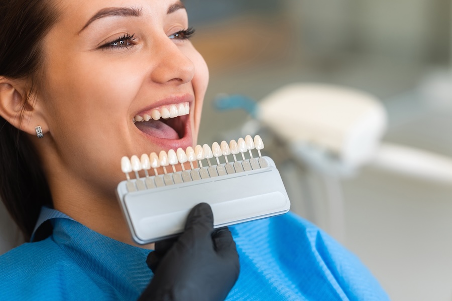 woman getting shade matched for lumineers vs veneers