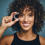 woman holding invisalign clear aligners