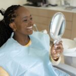 smiling woman in dental chair after cosmetic dentistry