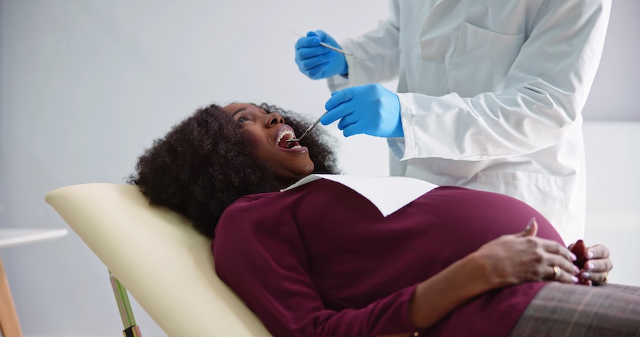 pregnant woman at dental office for dental cleaning or dental treatment to maintain gum health during pregnancy