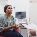 woman in dental chair asking dentist about metallic taste in mouth