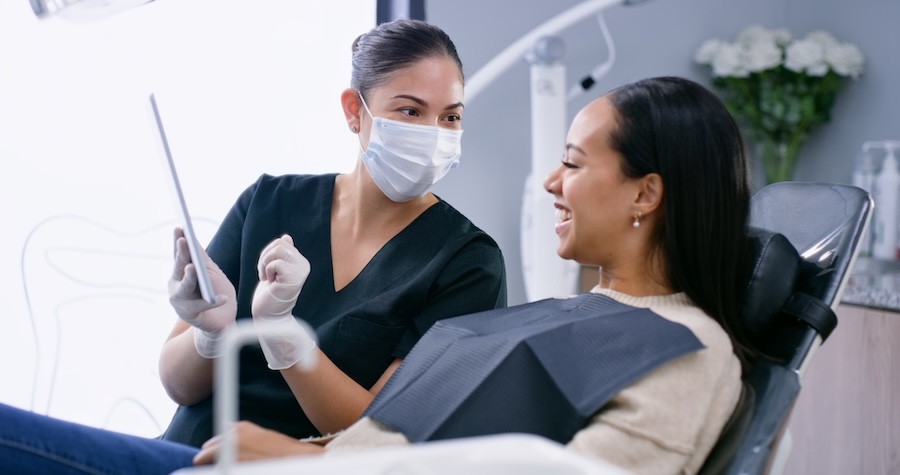 woman explaining treatment plan and dental insurance coverage to patient at dentist