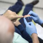 man at dentist discussing options to replace denture