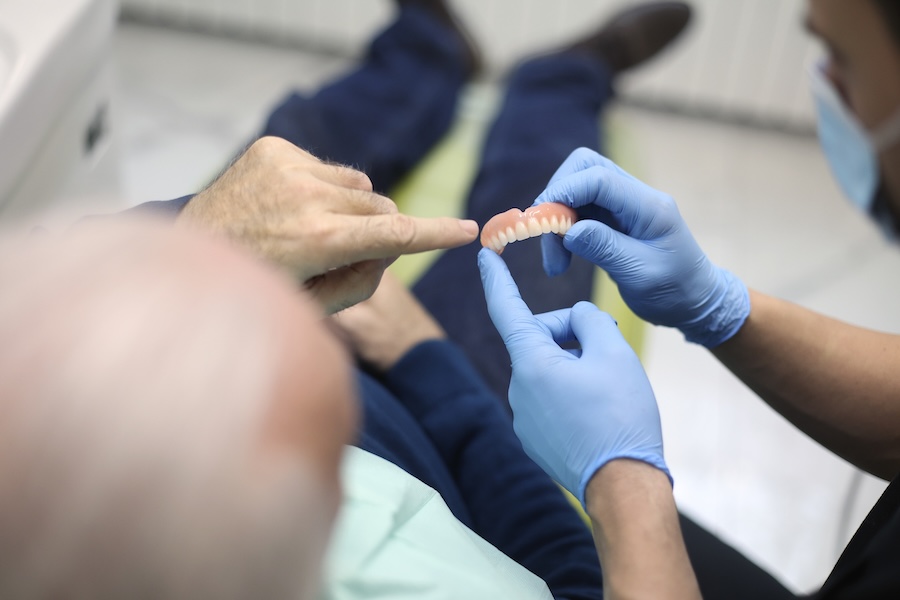 man at dentist discussing options to replace denture